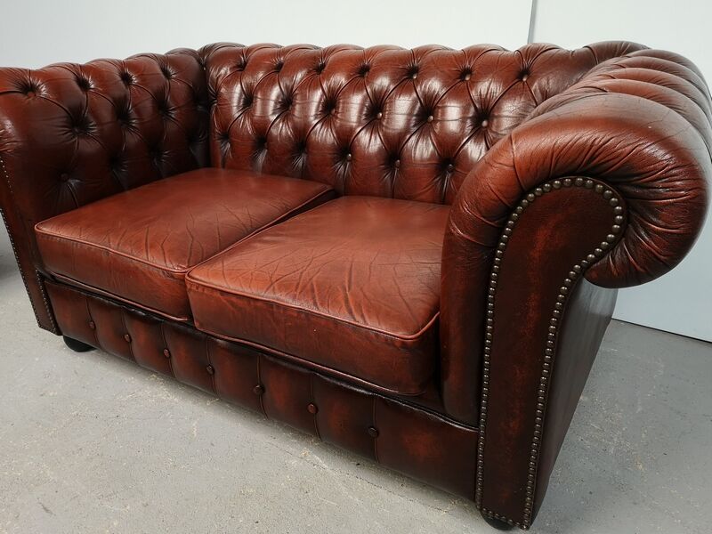 Two-seater brown leather chesterfield sofa