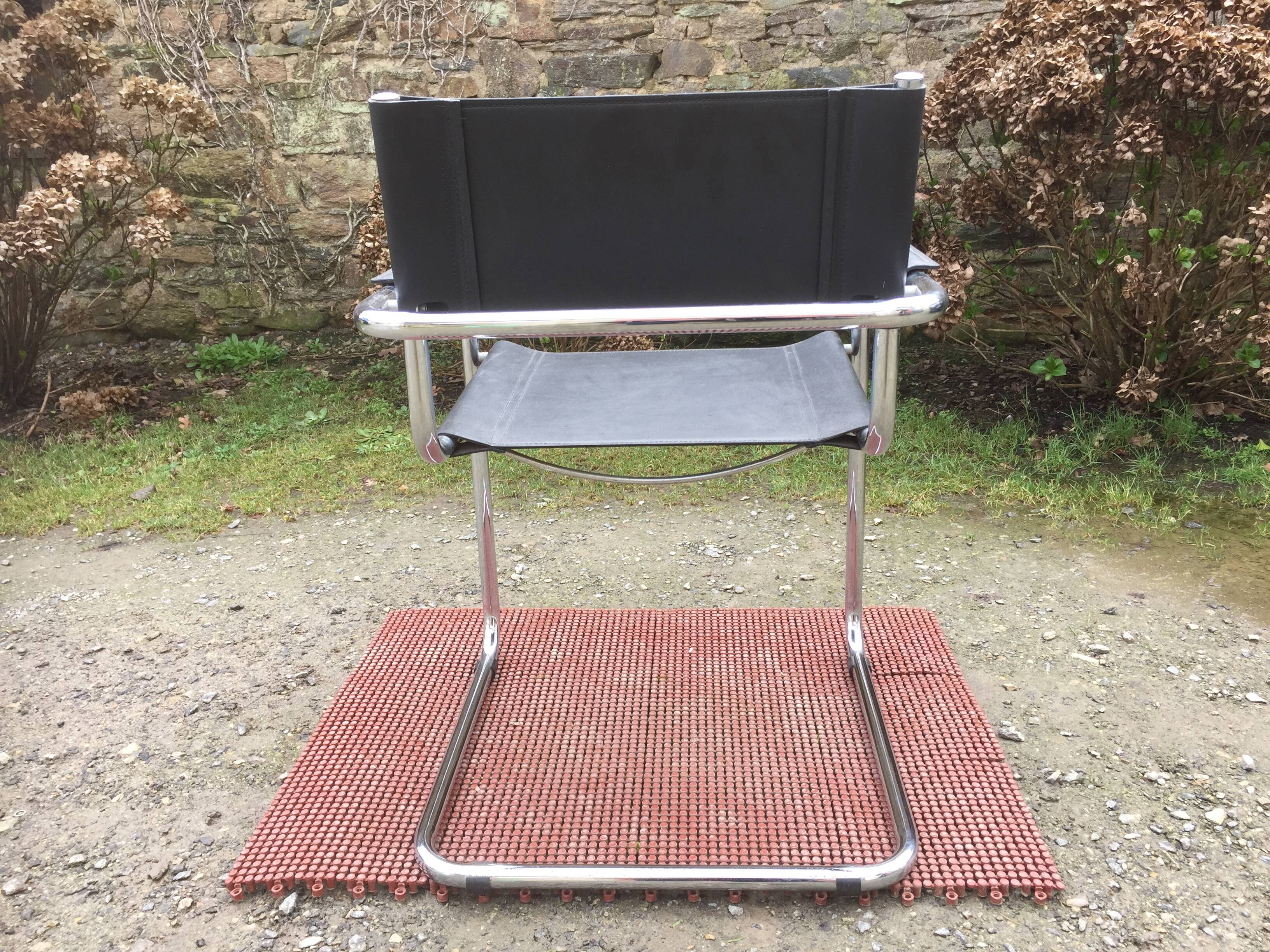 Design armchair with chrome metal tubular base and seat in black Skaï