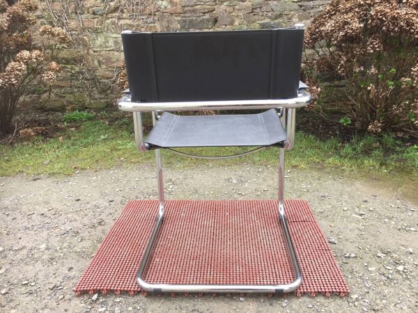 Fauteuil design à piétement tubulaire métallique chromé et assise en skaï noir