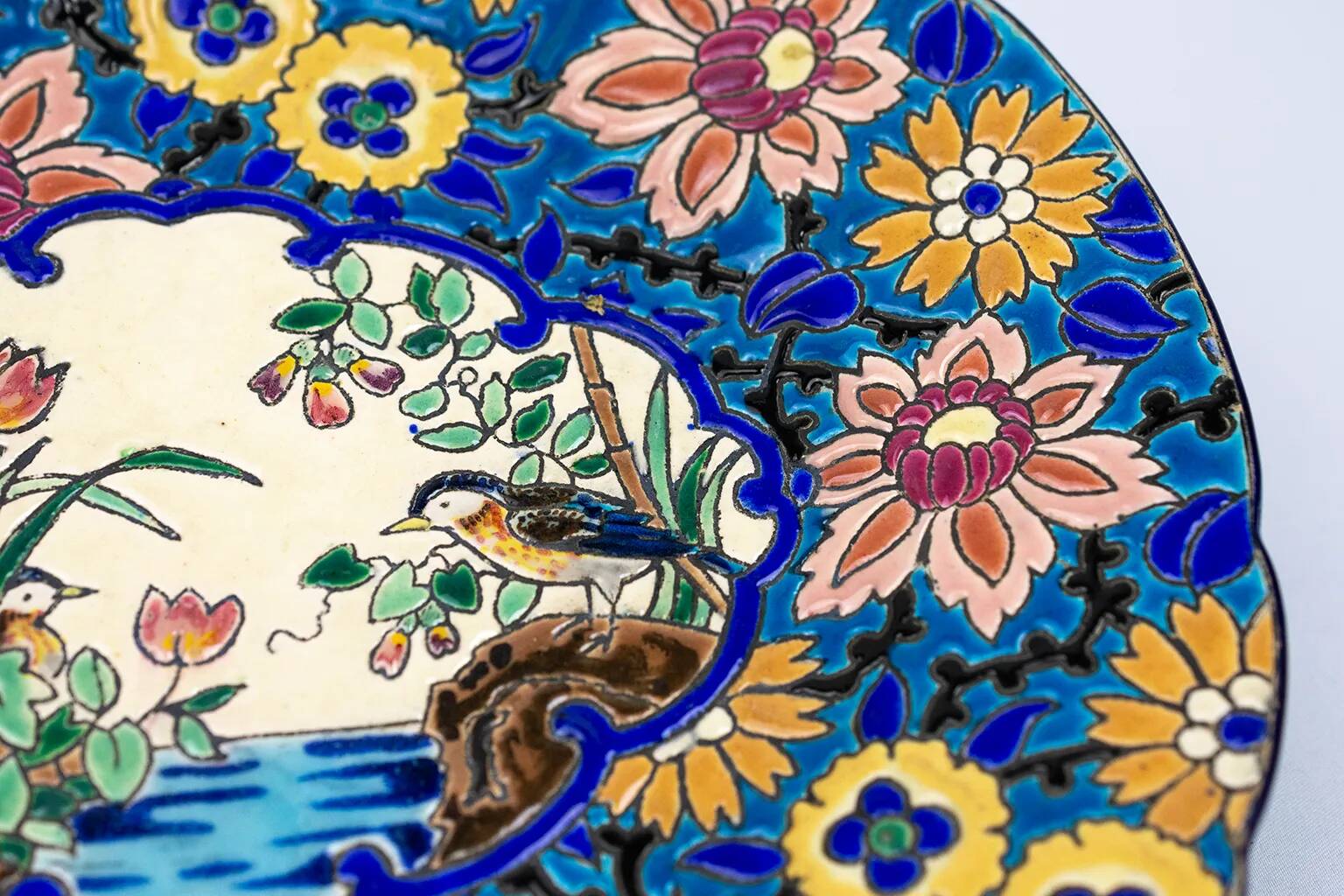 Assiette Longwy 1930 – Émaux à décor d’oiseaux et fleurs oranges