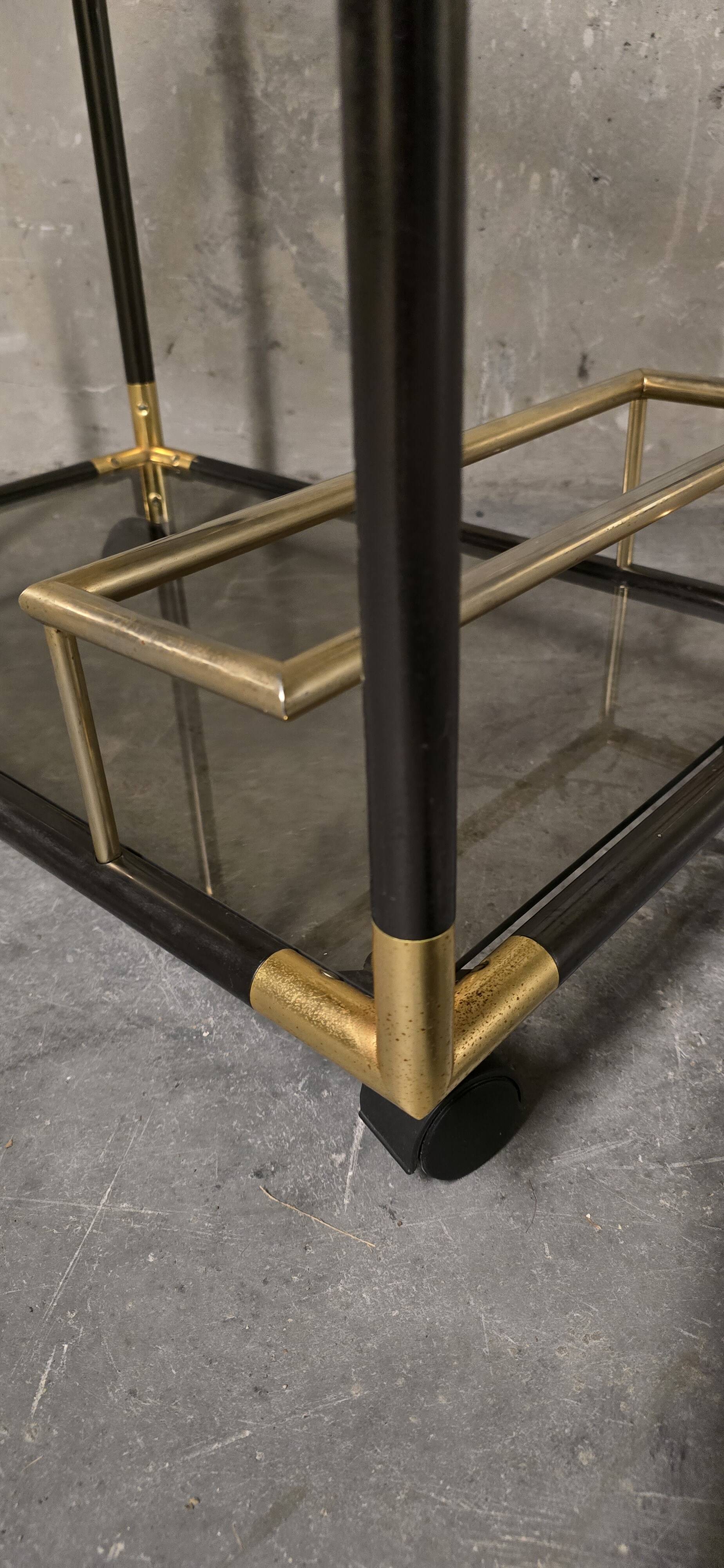 Black metal and brass rolling dessert trolley, smoked glass, 1970s.