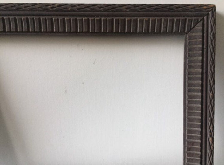 Antique wooden frame with geometric carvings light distress