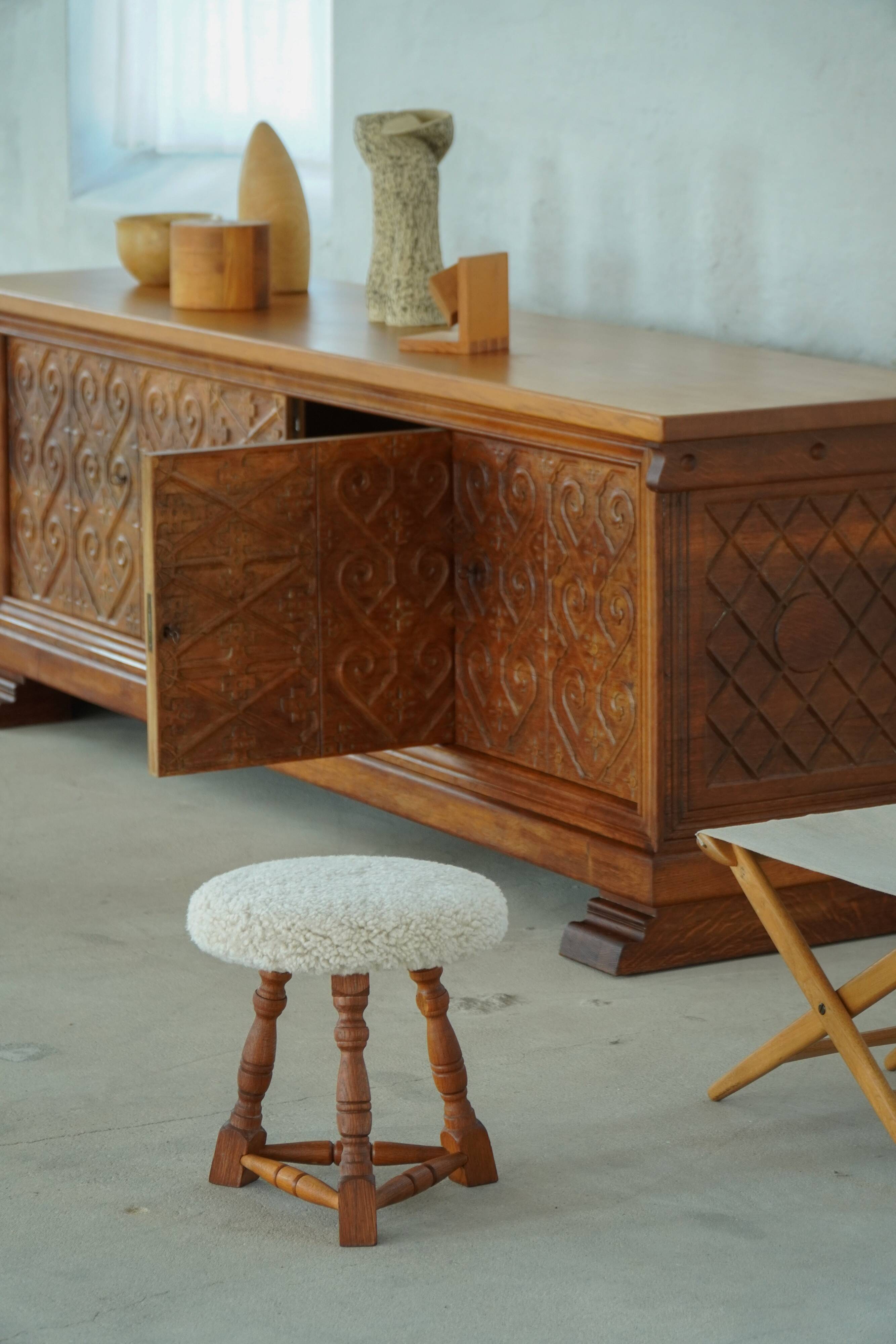 Modern Danish stool, with three oak legs featuring turned feet and a lambswool seat, 1950s.