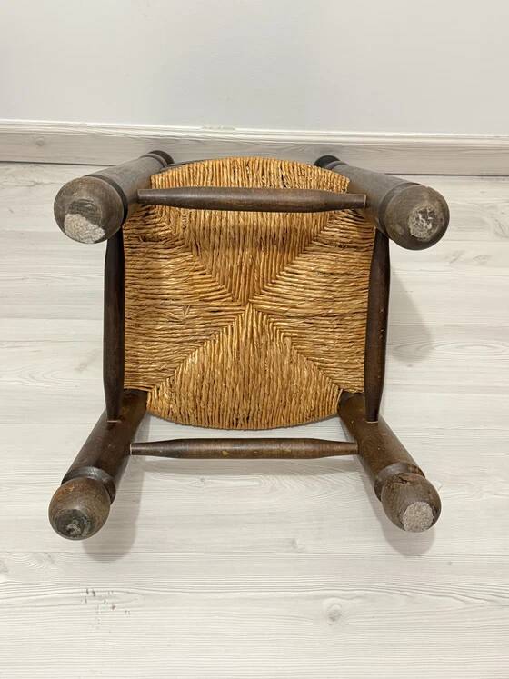 Low fireplace chair in the style of Charles Dudouyt – wood and straw seat.