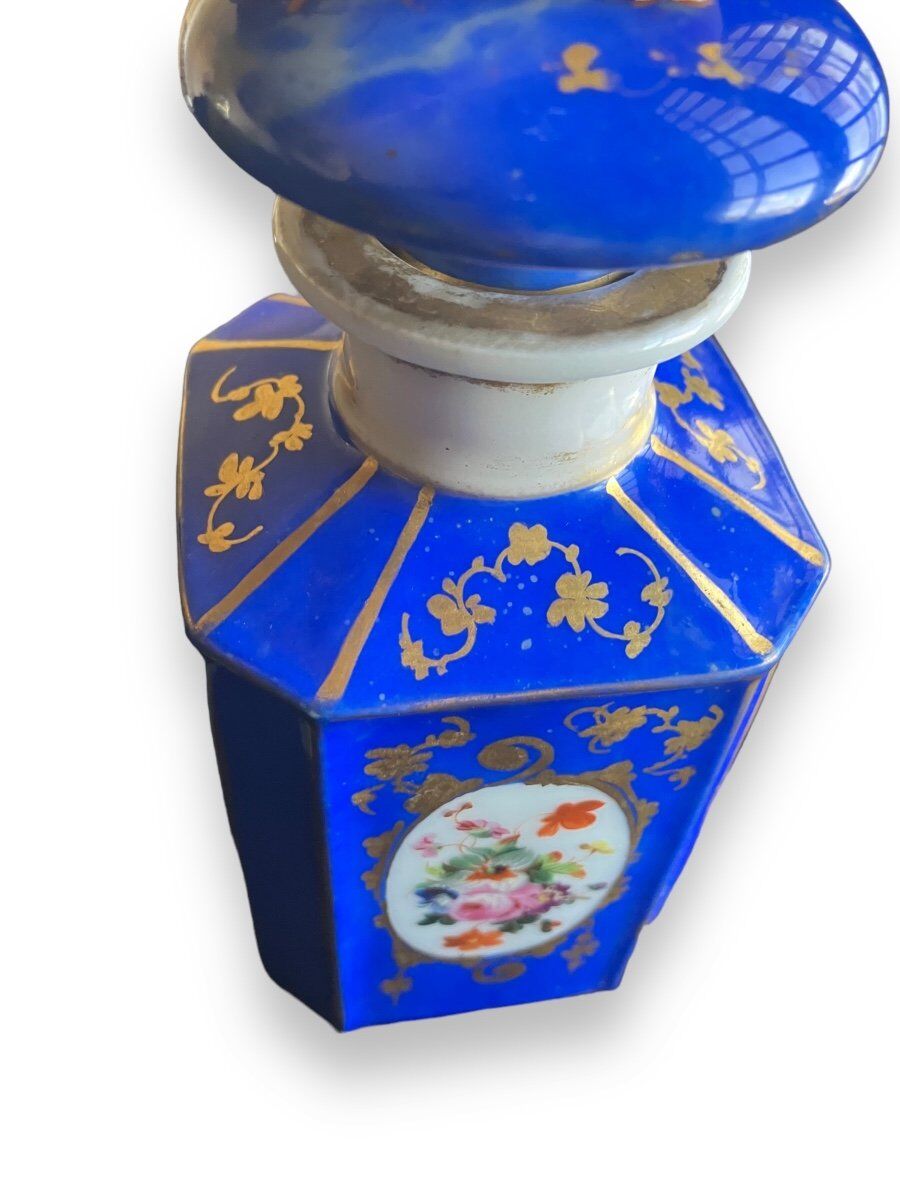 Perfume bottle in porcelain of old paris blue background