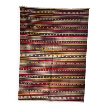 Large Indian rug with red, yellow, and white stripes and geometric fringes.