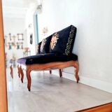 Old bench upholstered in black canvas flowers