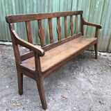 Duo of old solid oak benches with backs and armrests.
