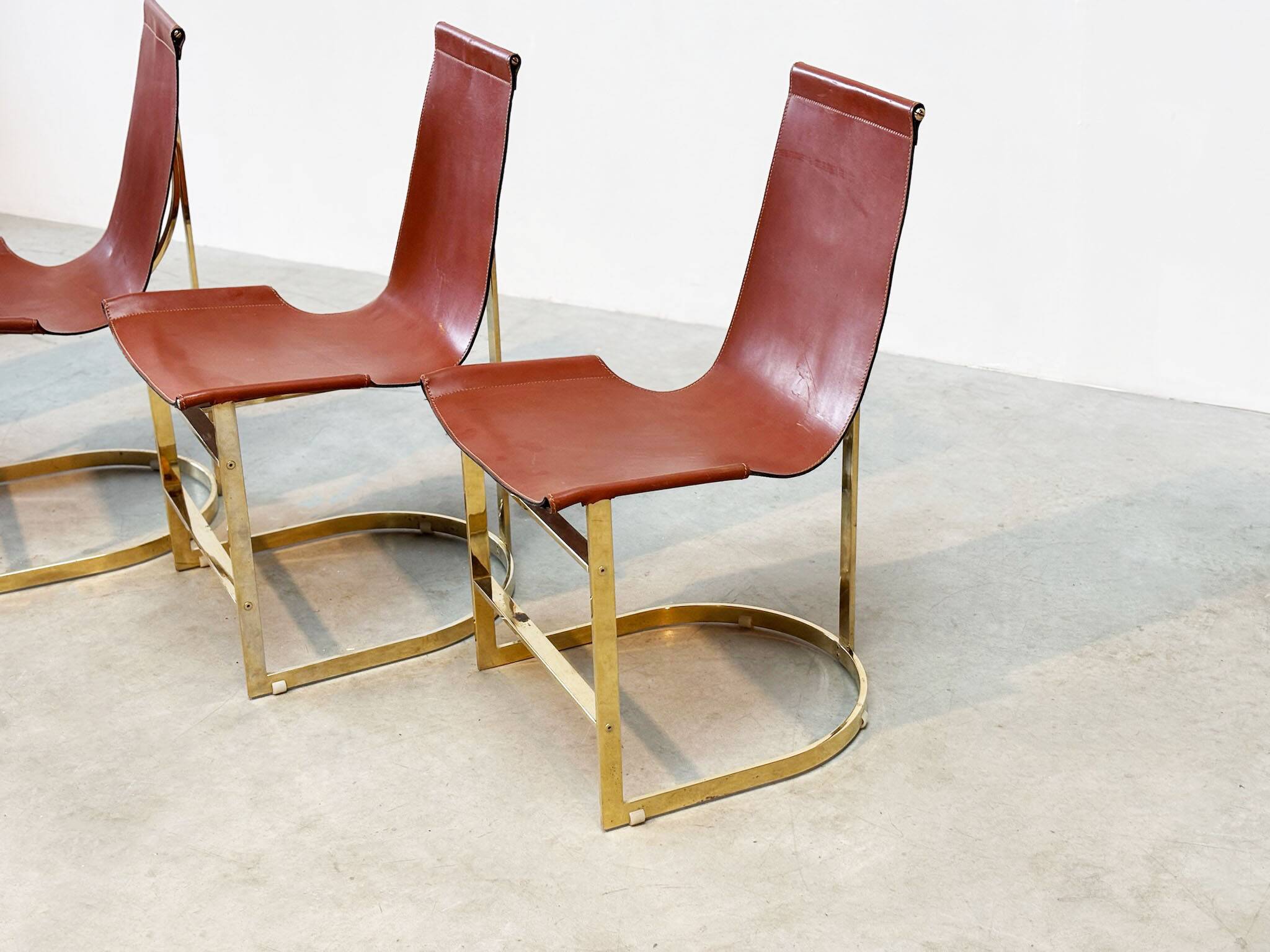 Set of four leather and brass Italian dining chairs
