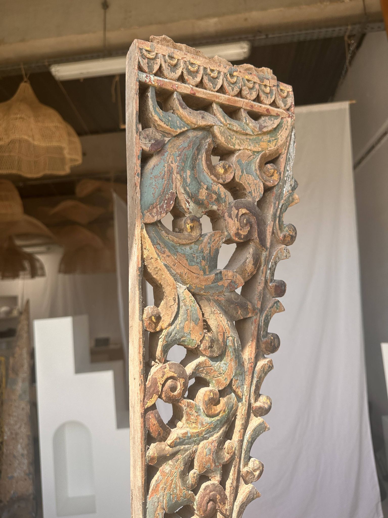 Indonesian construction element in carved wood with intertwined plant motifs mounted on a base (fri
