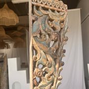 Indonesian construction element in carved wood with intertwined plant motifs mounted on a base (fri