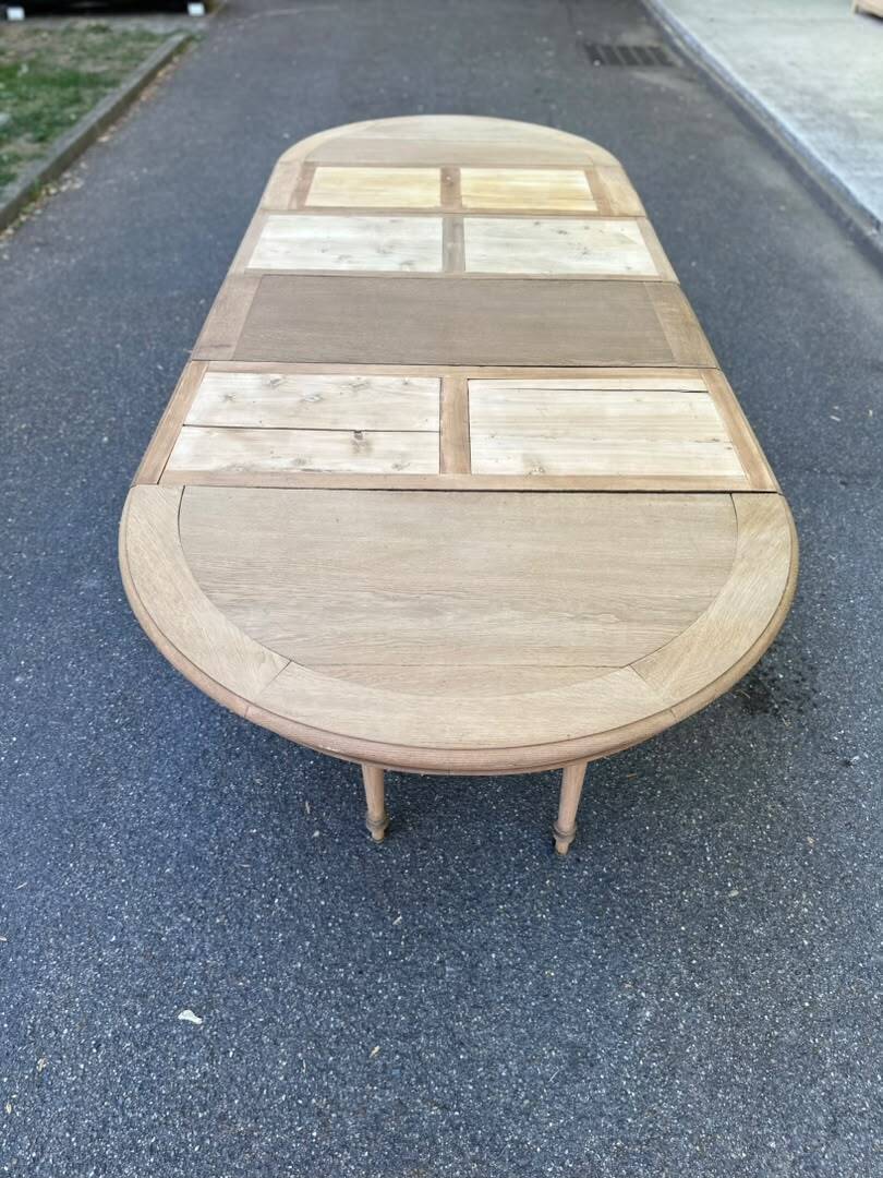 Round dining table with a central pedestal, stripped raw oak, 4 extensions, 19th century.