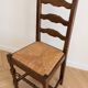 Set of 6 rustic wooden chairs with woven straw.