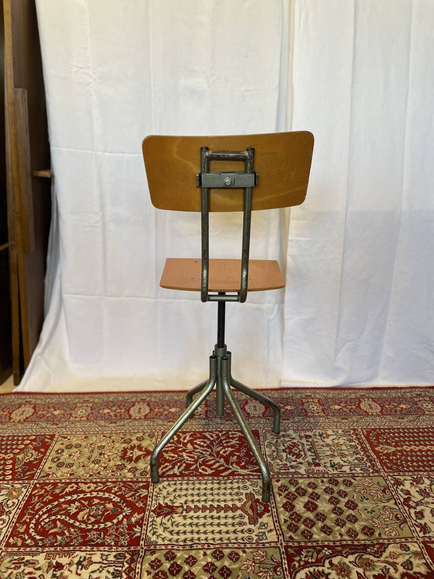 Old high workshop chair made of wood and metal.