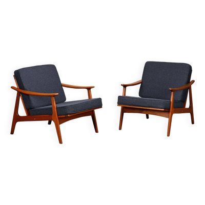 Paire de fauteuils modernes scandinaves en teck et en tissu bouclé bleu foncé.