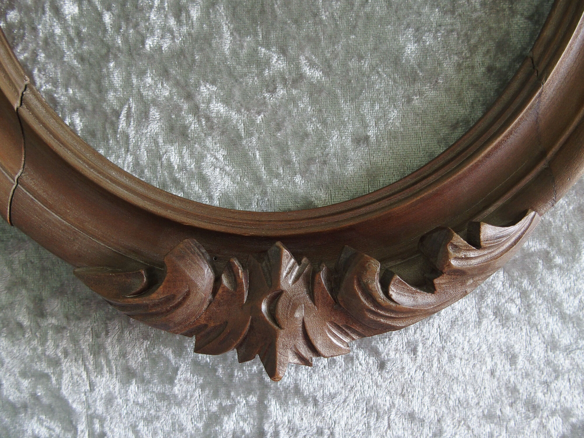 Wooden oval frame with carved pediment
