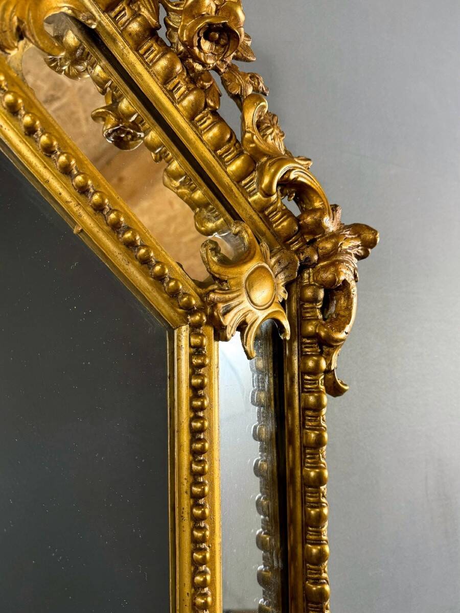 Antique octagonal mirror in richly carved gilded wood, Louis XV style.