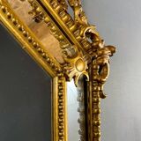 Antique octagonal mirror in richly carved gilded wood, Louis XV style.