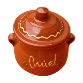 Covered pot with honey terracotta glazed floral decoration on a brown background