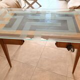 Elegant antique desk in cherry wood with a black leather top and glass plate.