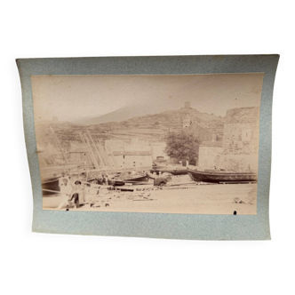 Photo album glued onto cardboard depicting a 19th-century port.