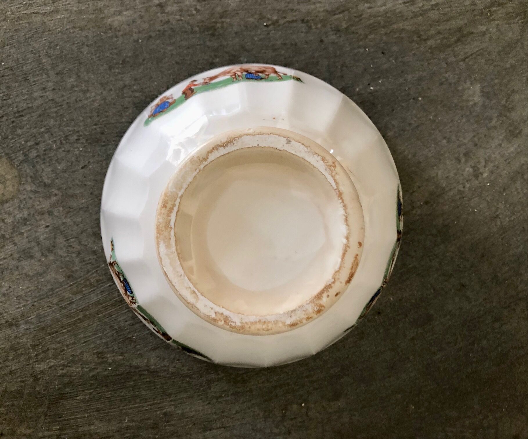 Old bowl decorated with a farmer and her cow