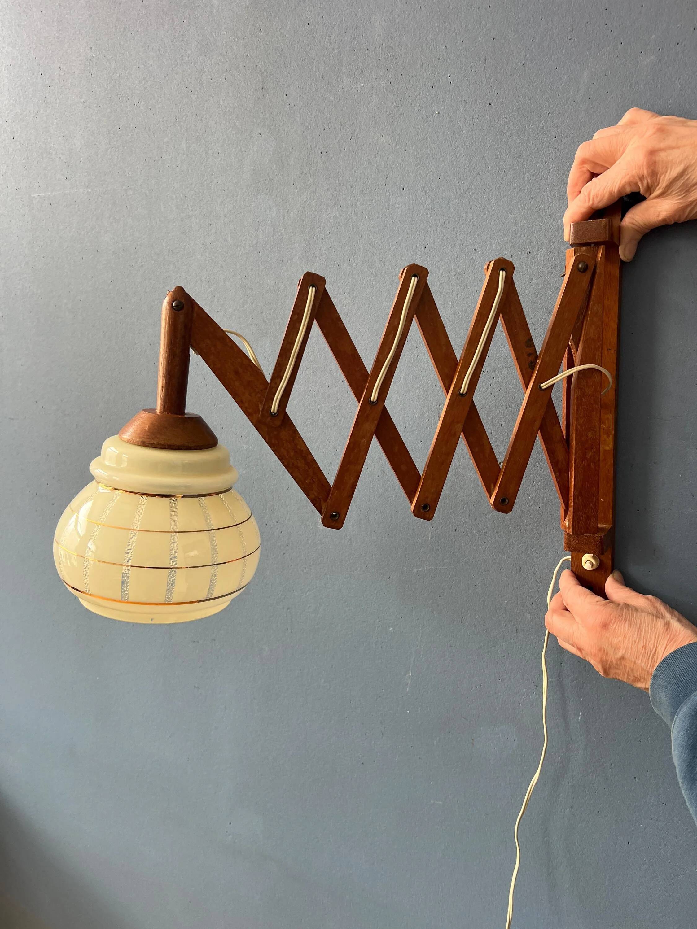 Vintage wall lamp with teak wood scissors and glass shade.
