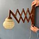 Vintage wall lamp with teak wood scissors and glass shade.