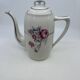Porcelain coffee service with floral decoration and silver trim.