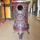 Old compact wood stove in enamelled cast iron with tripod feet with Lion's legs