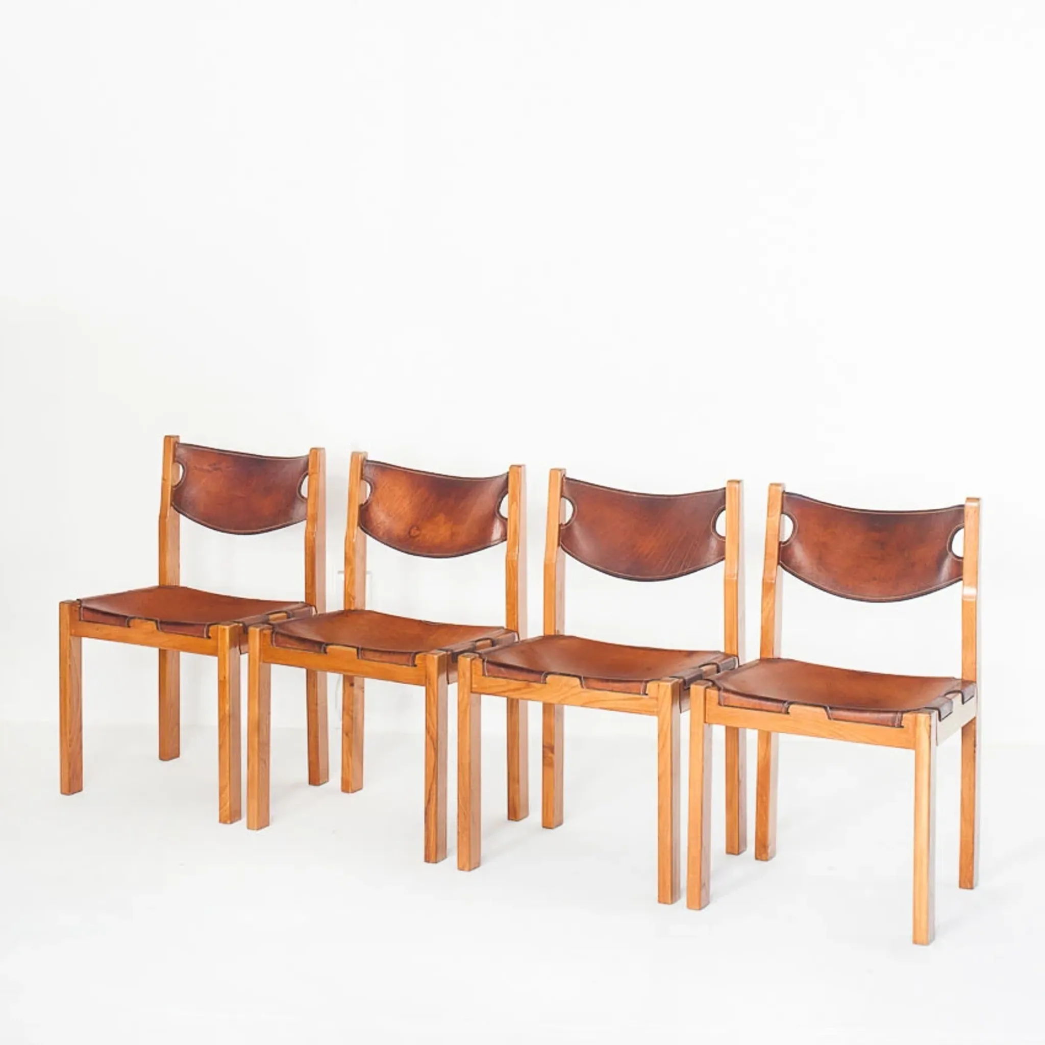 Ensemble de quatre chaises vintage. Bois d'orme et cuir. Maison Regain 70s