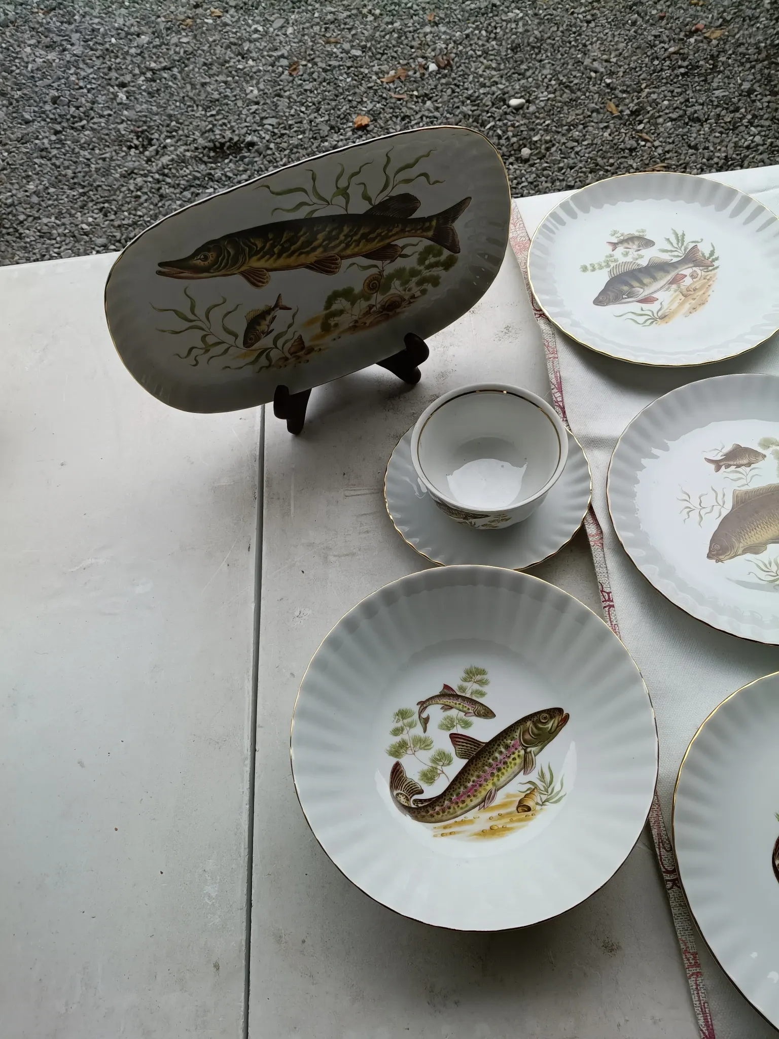 vintage porcelain dinner service with fish pattern and gold trim