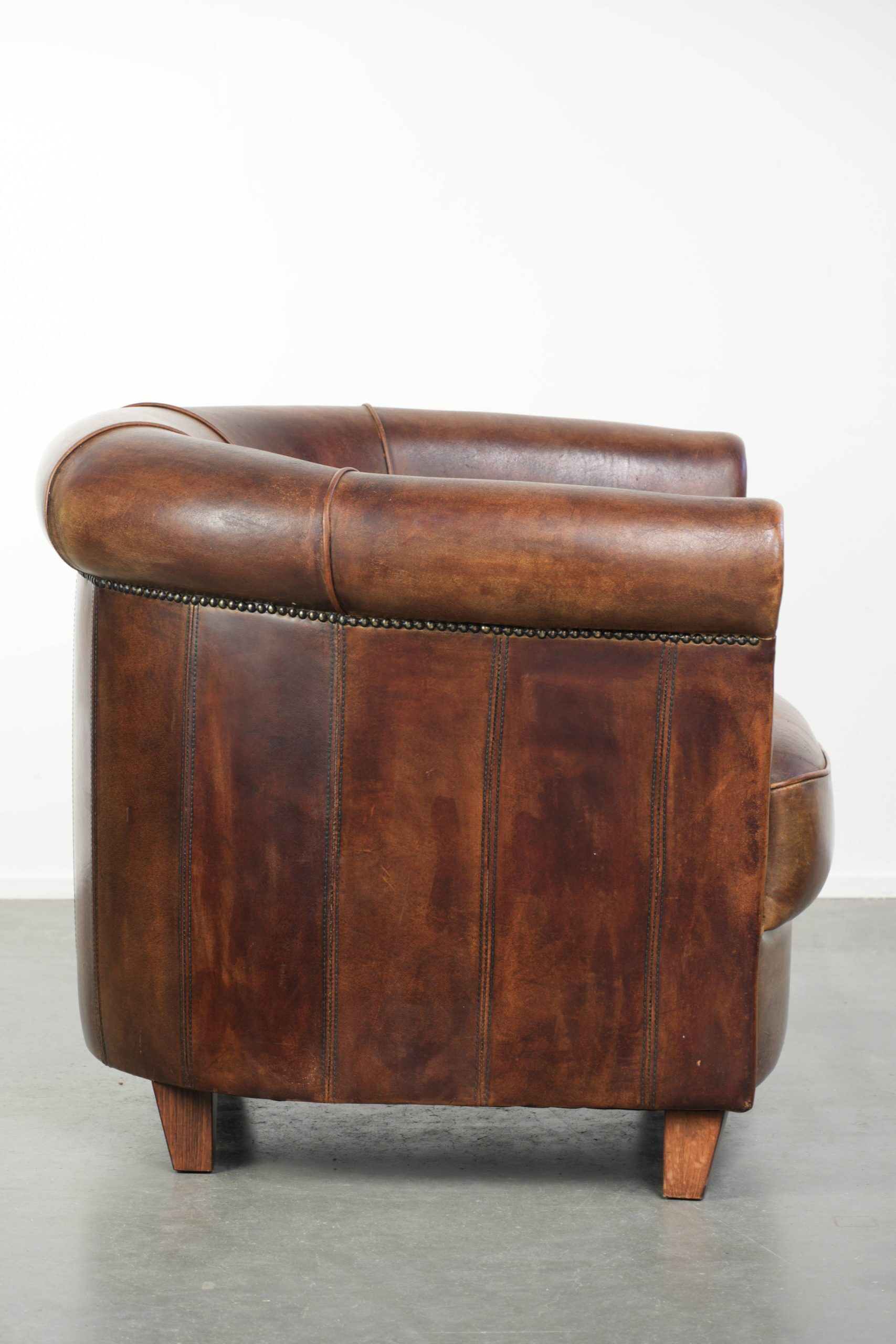 Sheepskin clubarmchair with beautiful patina finished with decorative nails