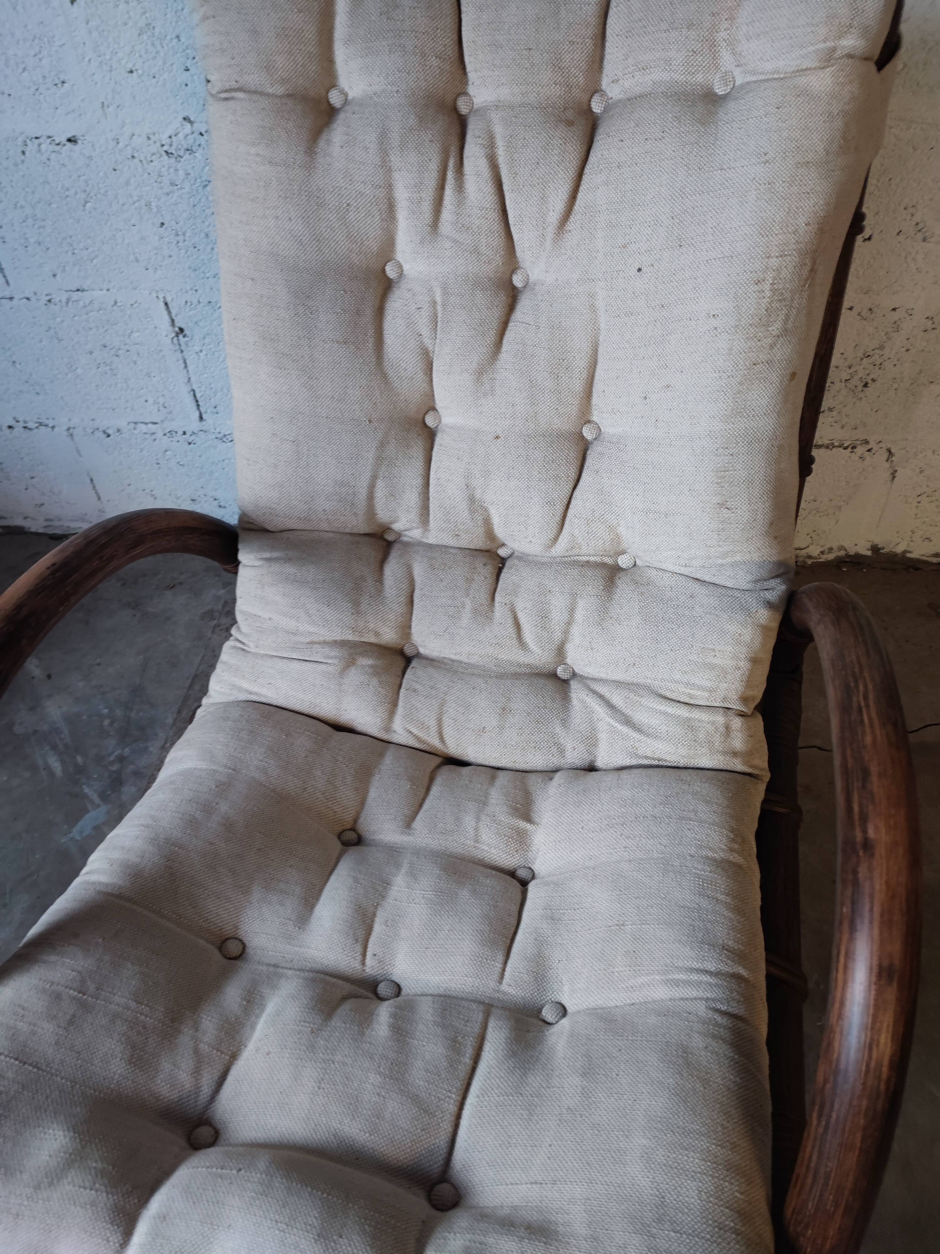 Relaxed armchair in bamboo and rattan with its small side table. Beige linen cushion.