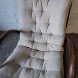 Relaxed armchair in bamboo and rattan with its small side table. Beige linen cushion.