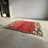Small wool rug, predominantly red with geometric patterns