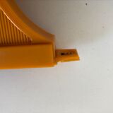 Tilting orange plastic mirror with its matching wall light
