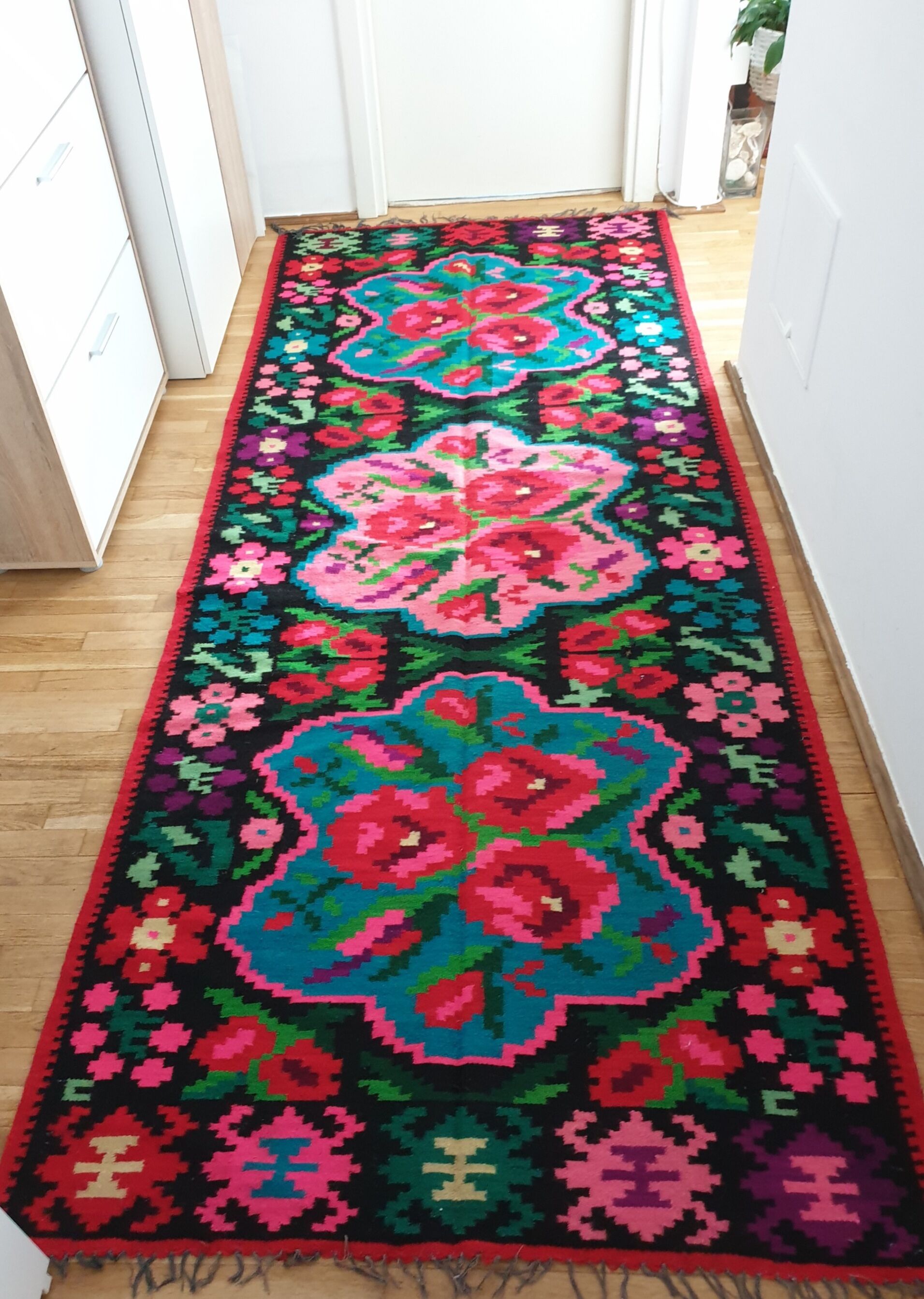 Colorful kilim on black background with floral design