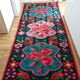 Colorful kilim on black background with floral design