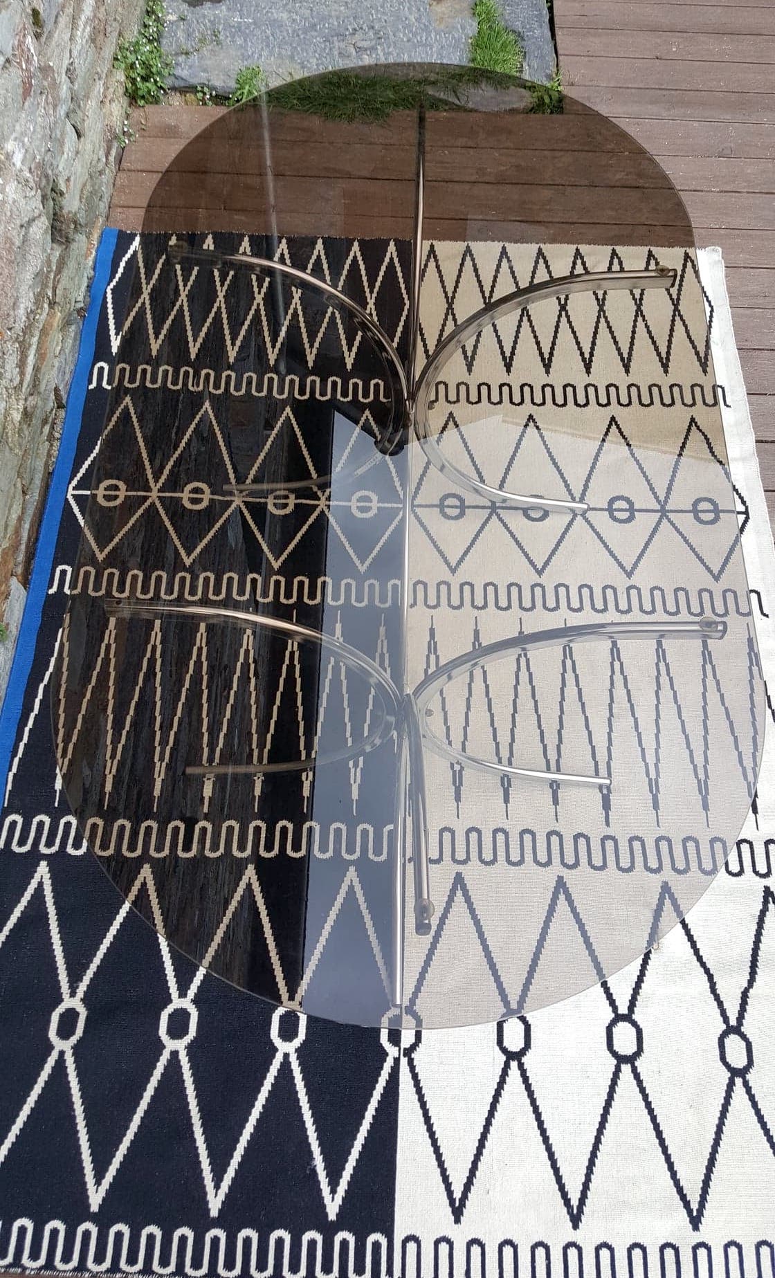 Oval table in smoked glass and metal foot