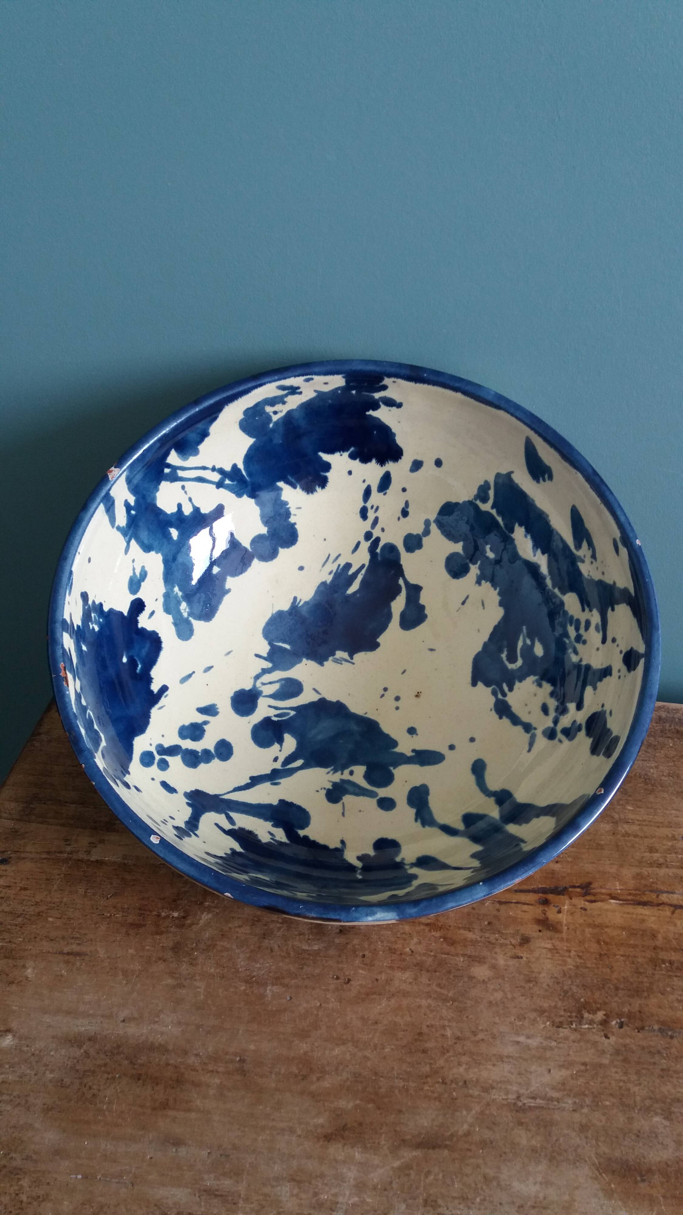 Empty pocket bowl in terracotta, glazed with "ink spots" design.