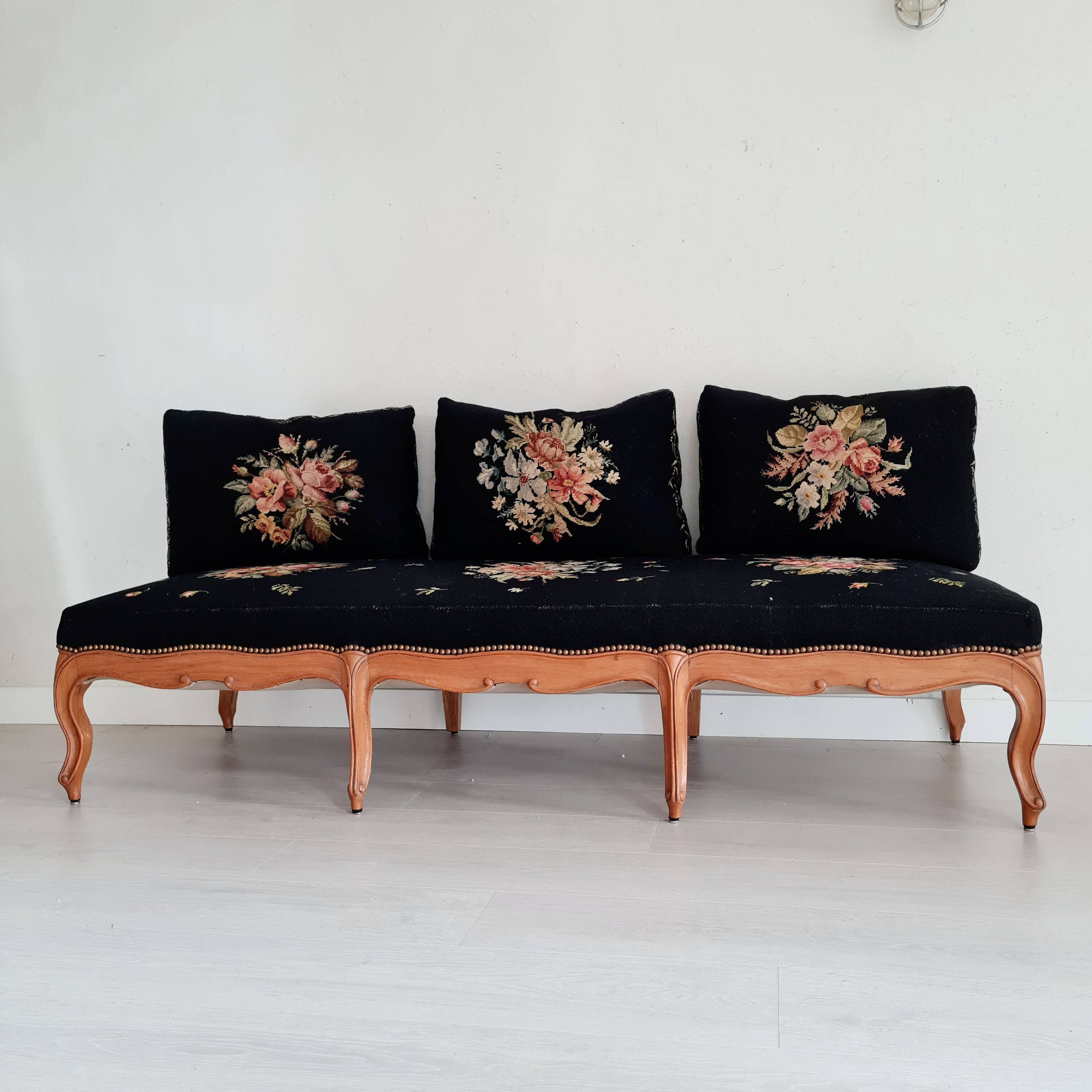 Old bench upholstered in black canvas flowers
