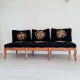 Old bench upholstered in black canvas flowers