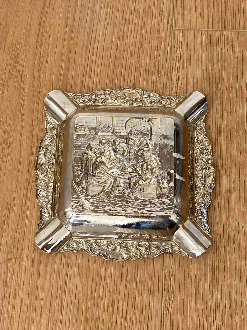 Antique silver-plated ashtray, decorated with repoussé scenes of a tavern, pin tray.