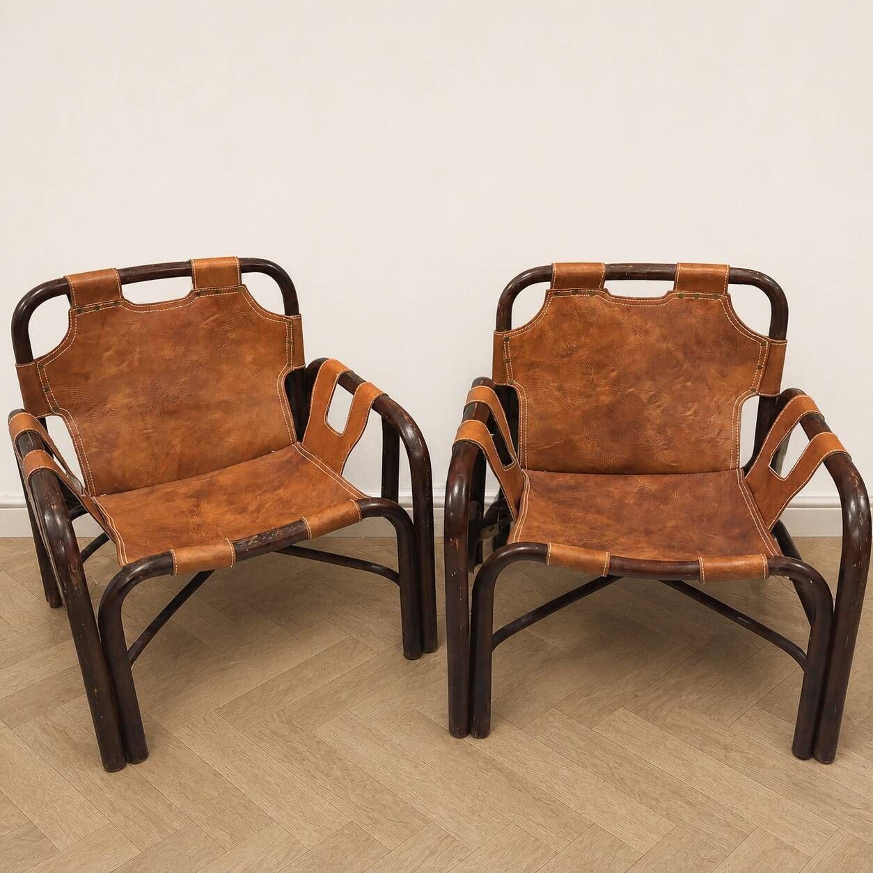Pair of Tito Agnoli armchairs in leather and bamboo, 1970s.