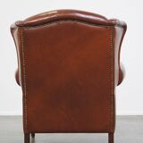 Correct, comfortable, luxurious English-style wingback armchair made of cognac-colored cow leather
