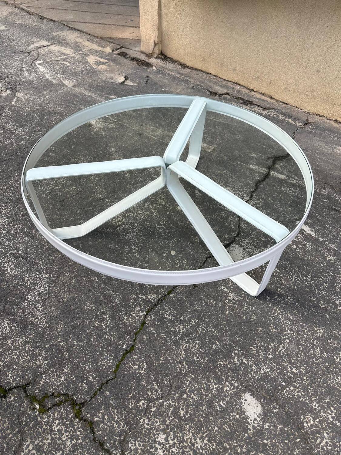 Round coffee table with a metal/leather frame and glass top by Roche Bobois.