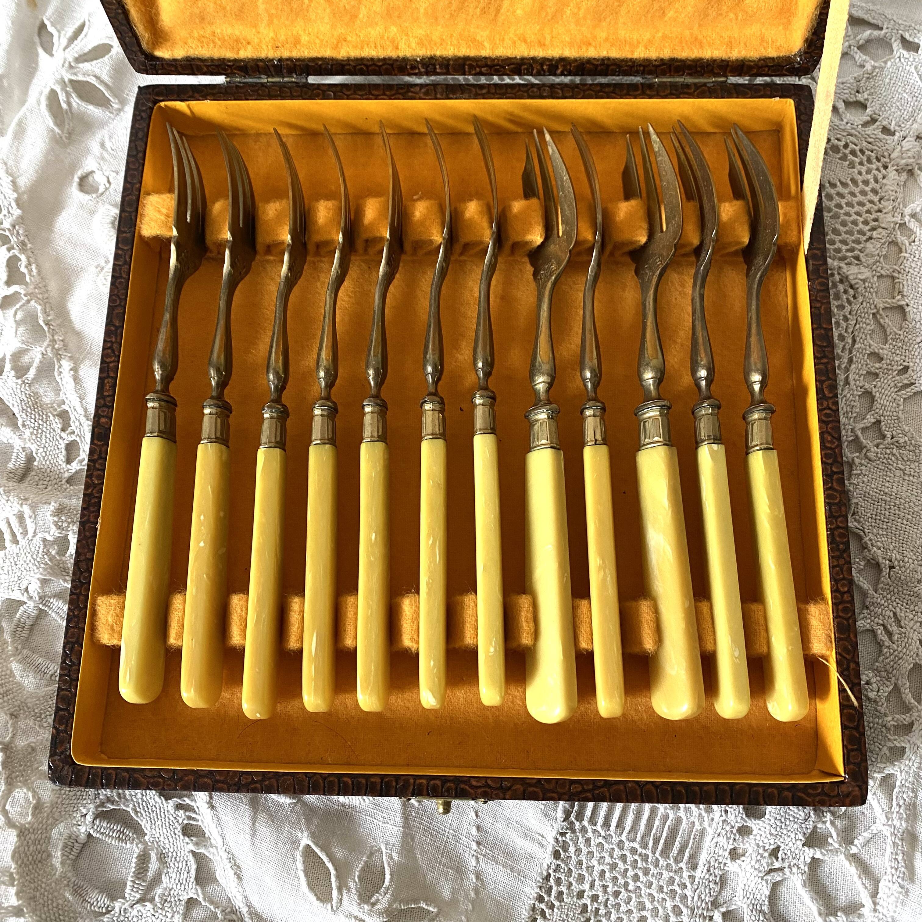 Antique dessert forks in brass and bakelite