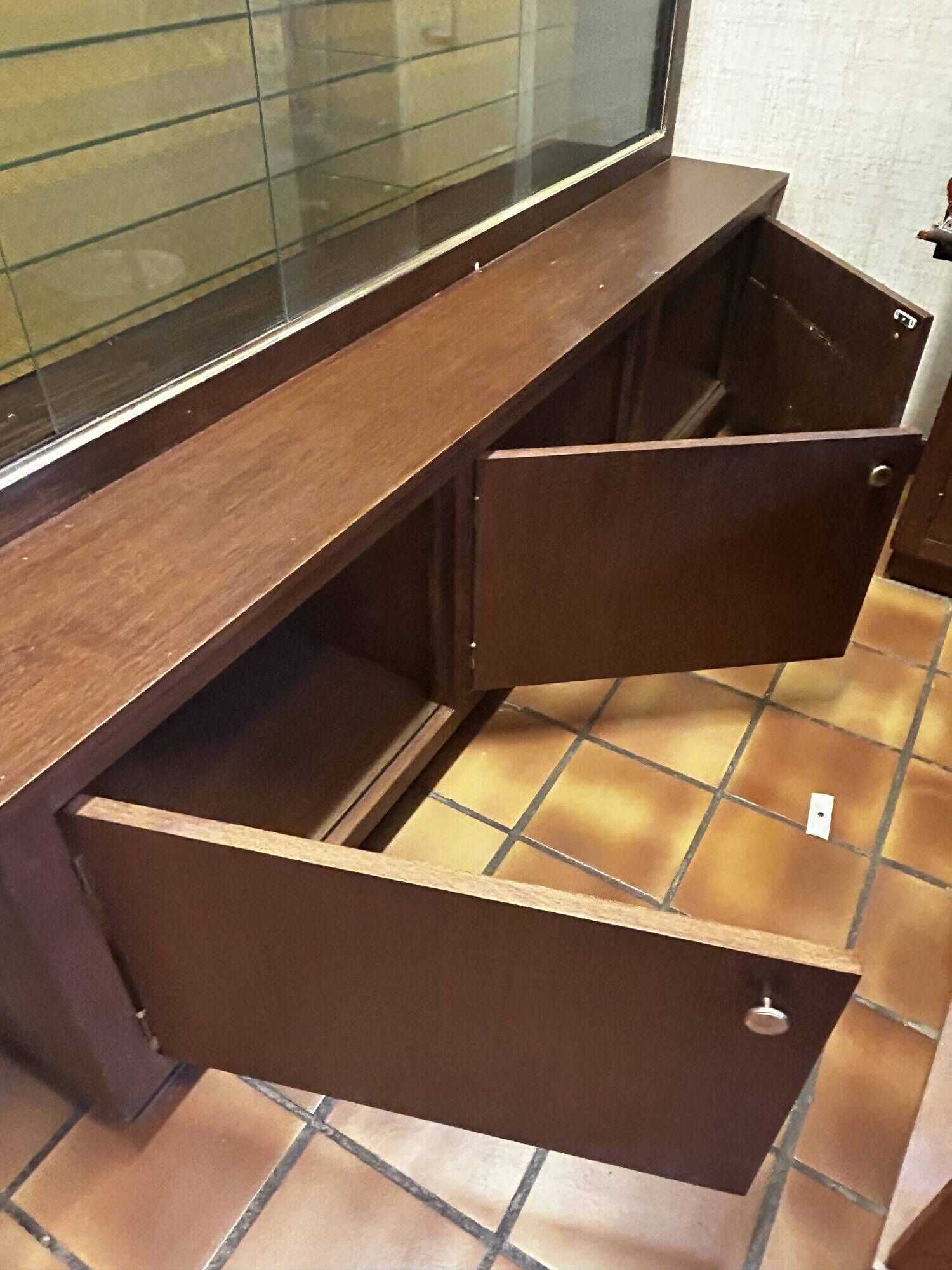 Vintage wooden and glass display cabinet, 15 shelves, gold background.