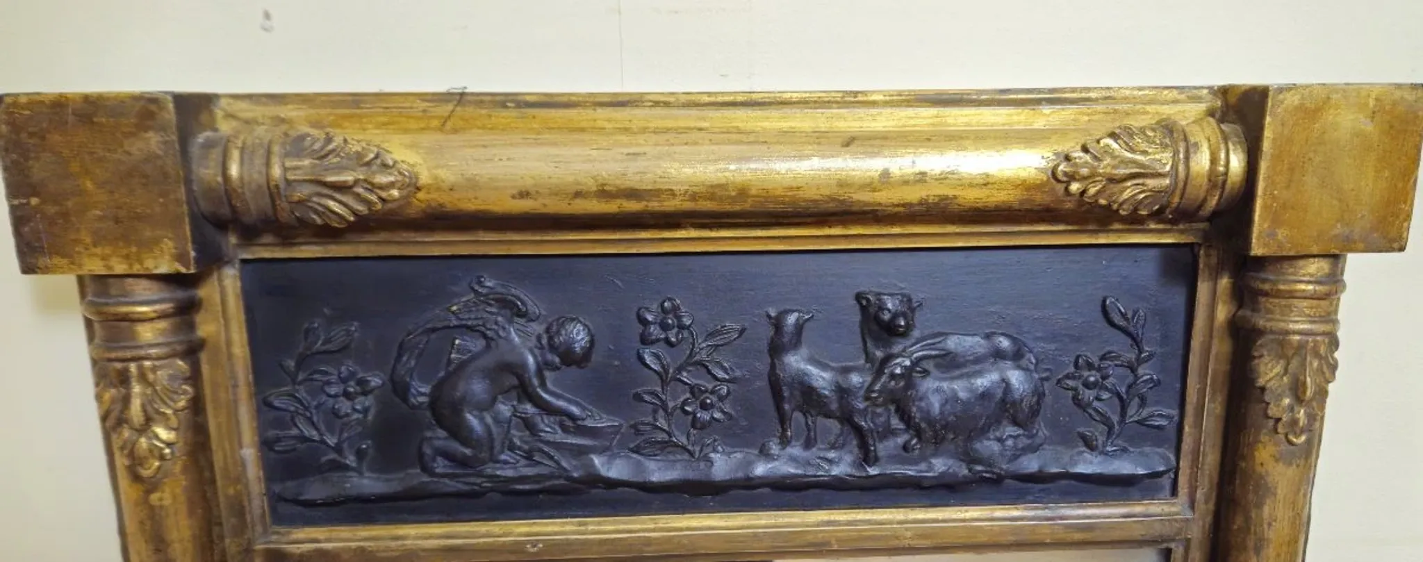 Large antique gilded wooden mirror with terracotta relief from the Empire period.